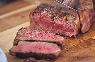 写真：BBQで焼かれたお肉を切り分けている