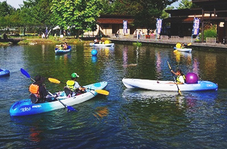 写真：「冒険の池」でカヤックを漕いでいる参加者