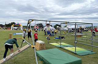 写真：跳び箱や板、棒などを組み合わせた設備を移動している子供達
